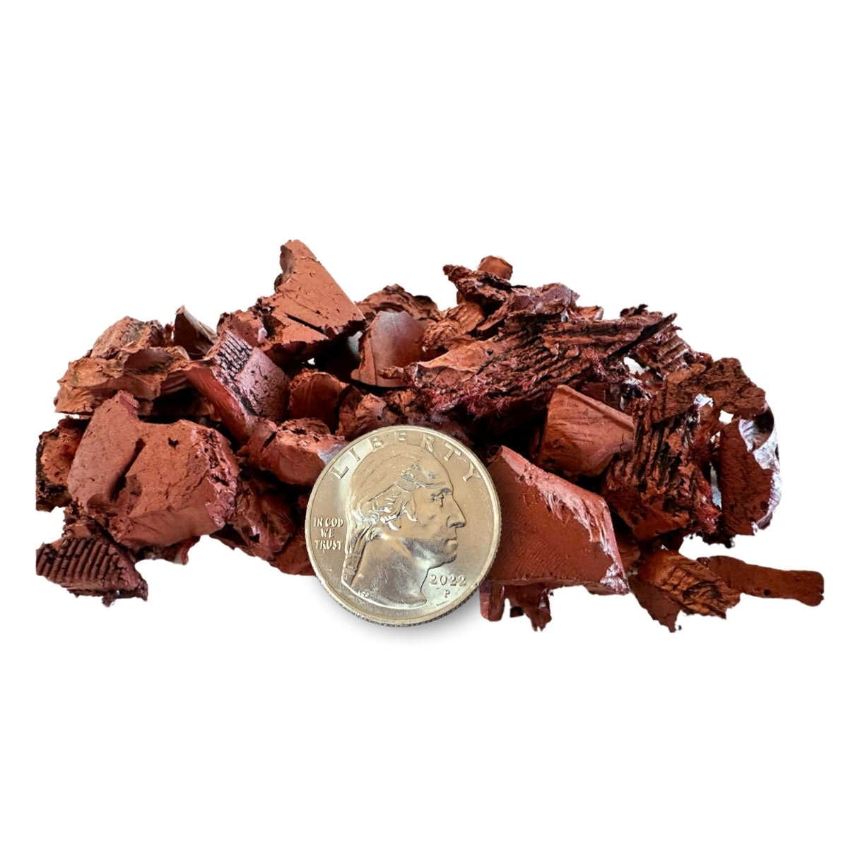 Brown mineral sample with a coin for scale on a white background